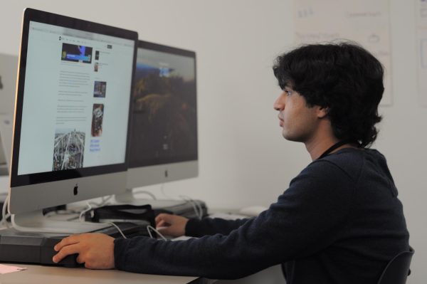 Senior Shahmeer Mirza reading a news article on Thursday, Oct. 10, 2024. 